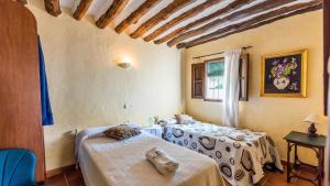 a bedroom with two beds and a window at Molino Jabonero Villanueva del Trabuco by Ruralidays in Villanueva del Trabuco +27 photos