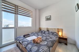 a bedroom with a bed with a dog laying on it at Cozy Apartment with Balcony on the Black Sea- part of the family 'Vicki Apart in Varna City