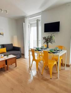 een woonkamer met een eettafel en gele stoelen bij Sunny Terrace - Lovely Center Apartments Alameda in Sevilla