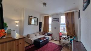 a living room with a couch and a table at Extra Large One Bedroom Flat with Parking in London