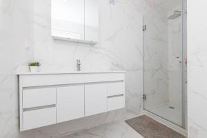 セジンブラにあるCasa das Andorinhas - T2 renovado com terraçoの洗面台とシャワー付きの白いバスルーム +18枚の写真