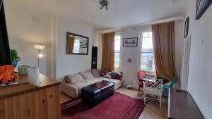 a living room with a couch and a table at Extra Large One Bedroom Flat with Parking in London