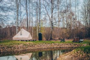 a tent next to a body of water with trees at Glamping in - luxury tent in Šunupis +43 photos