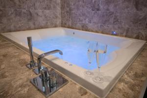 a bath tub with two wine glasses in it at Hawkshead Suites in Hawkshead