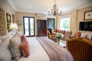 - une chambre avec un grand lit et un salon dans l'établissement Kilima Franschhoek, à Franschhoek