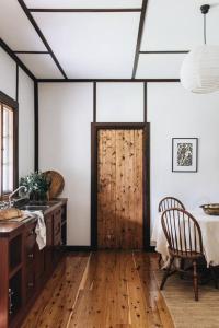 Habitación con puerta de madera, escritorio y silla. en Pickers Hut en Basket Range