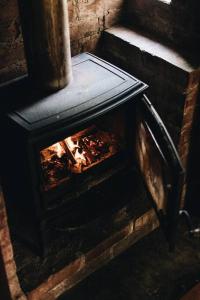 un horno de ladrillo con un fuego dentro de él en Pickers Hut en Basket Range