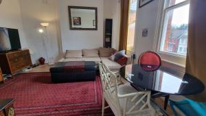 ein Wohnzimmer mit einem Sofa und einem Tisch in der Unterkunft Extra Large One Bedroom Flat with Parking in London