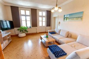 un ampio soggiorno con divani e TV di Villa Bertha a Ostseebad Sellin
