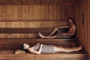 een man en een vrouw die in een sauna liggen bij Hotel habicher hof 4-Sterne-Superior in Oetz