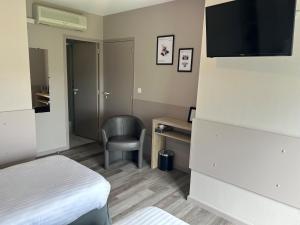 een hotelkamer met een bed en een stoel bij Logis Les Voiliers in Peigney