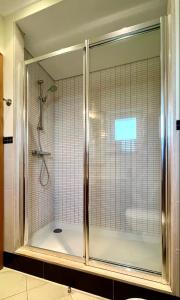 y baño con ducha y puerta de cristal. en Casa Ana at Opomar by Cara Rentals, en Tavira