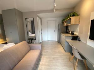 a living room with a couch and a kitchen at Loft Grid Liberdade in São Paulo