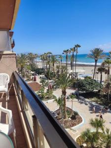 a view of the beach from the balcony of a resort at Estepona, apartamento en primera linea de playa in Estepona