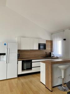 a kitchen with white appliances and a wooden floor at APARTMENTS MARINA in Marina