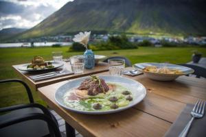 une table en bois avec des assiettes de nourriture au-dessus dans l'établissement Hotel Isafjördur - Torg, à Ísafjörður