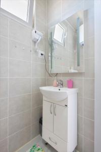 a bathroom with a white sink and a mirror at APARTMAN OAZA in Pelinovo