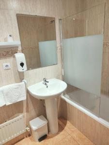uma casa de banho com um lavatório, um espelho e uma banheira em Hotel Acebo Plaza Mayor em Jaca