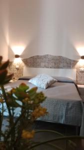1 dormitorio con 1 cama con 2 lámparas en Appartamenti turistici Aprile Antonio Luigi, en Borgagne