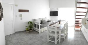 sala de estar blanca con mesa y sofá en Depto Pellegrini Tandil en Tandil