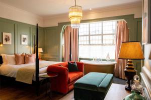 a bedroom with a bed and a chair and a window at The Canford in Poole