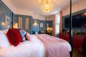 a bedroom with a large bed with red pillows at The Canford in Poole