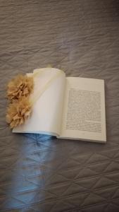 un libro abierto con una flor seca en una cama en Appartamenti turistici Aprile Antonio Luigi, en Borgagne