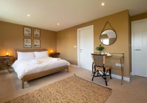 a bedroom with a bed and a desk and a mirror at Barton Farm in West Down