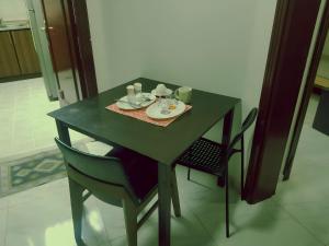 a green table with two chairs and a plate andoverty at Abu Dhabi Centre - Unique Room in Abu Dhabi