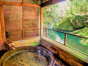 LiVEMAX RESORT Shizuoka Amagiyugashima في إيزو: غرفة مع نافذة مطلة على النهر