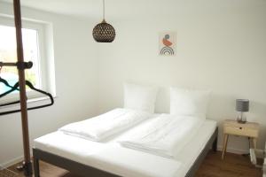 a white bed in a room with a window at Exklusive Neubauwohnung mit wundervoller Aussicht nähe Europapark und Rulantica in Burgheim