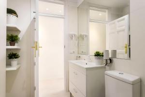 a white bathroom with a toilet and a sink at Lux City Loft in front of the Port in Alicante