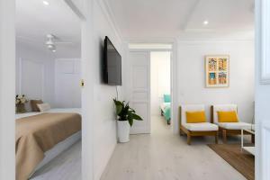 a white bedroom with a bed and two chairs at Lux City Loft in front of the Port in Alicante