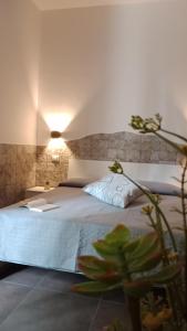 Un dormitorio con una gran cama blanca y una planta en Appartamenti turistici Aprile Antonio Luigi, en Borgagne