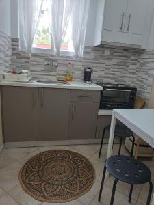 eine Küche mit einer Spüle sowie einem Tisch und Stühlen in der Unterkunft Meltemi apartments in Agia Marina