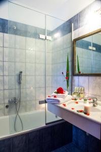 La salle de bains est pourvue d'une douche, d'un lavabo et d'une baignoire. dans l'établissement Hotel Porto Koufo, à Porto Koufo