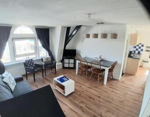 - un salon avec un canapé et une table dans l'établissement Appartementen Zandvoort, à Zandvoort