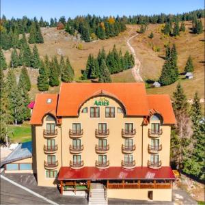 an apartment building with an orange roof on a mountain at Aries Vârtop in Vartop