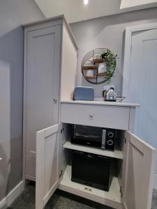 a white cabinet with a microwave in a room at The Boathouse in Lee-on-the-Solent