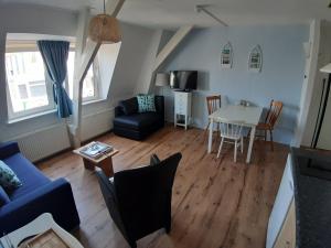 een woonkamer met een blauwe bank en een tafel bij Appartementen Zandvoort in Zandvoort