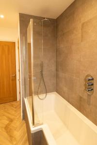 Das Bad ist mit einer Dusche und einer Badewanne ausgestattet. in der Unterkunft Lovely 2- Bedroom Apartment with Stunning Sea Views in Worthing