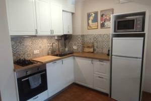 uma cozinha com armários brancos e um frigorífico branco em Apartamento a pie de pistas em La Molina