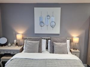 a bedroom with a bed with two tables and a picture at The Boathouse in Lee-on-the-Solent