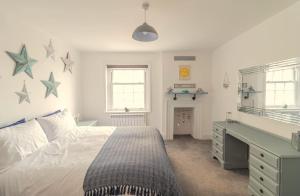 Lovely 2- Bedroom Apartment with Stunning Sea Views في وورثينغ: غرفة نوم بسرير ومكتب النجوم على الحائط