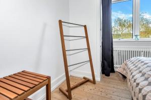 Una escalera apoyada en una pared junto a una cama en Plads til 4 personer - 5 minutter fra Friluftsbadet en Aalborg