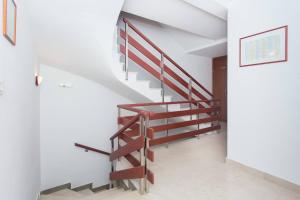 una escalera en una casa con barandillas de madera en Apartments Betanija, en Trogir