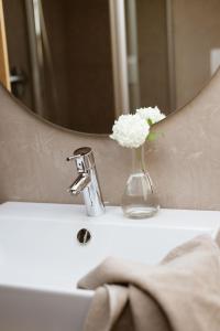 a vase of flowers sitting on a bathroom sink at Chalet Ansitz Pastreinbach in Appiano sulla Strada del Vino
