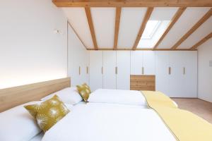 a bedroom with two white beds and a skylight at Chalet Ansitz Pastreinbach in Appiano sulla Strada del Vino