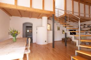 a room with a table and a spiral staircase at Chalet Ansitz Pastreinbach in Appiano sulla Strada del Vino