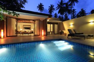 a swimming pool in front of a house at night at Anantara Peace Haven Tangalle Resort in Tangalle